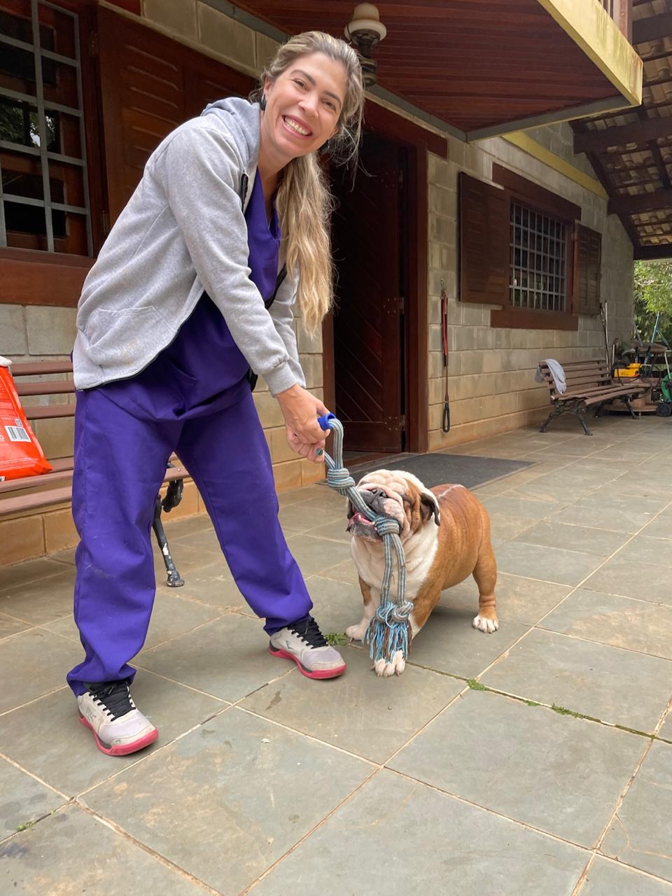Dra. Bruna brincando de cabo de guerra com um buldogue